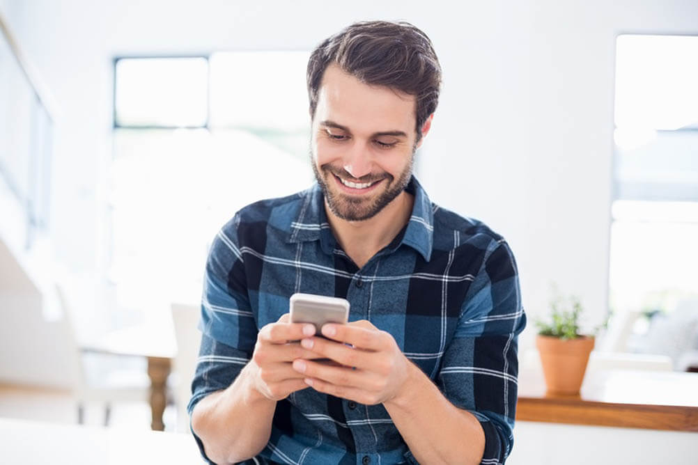 Which Lottery Numbers to Avoid Man looking at smartphone and smiling