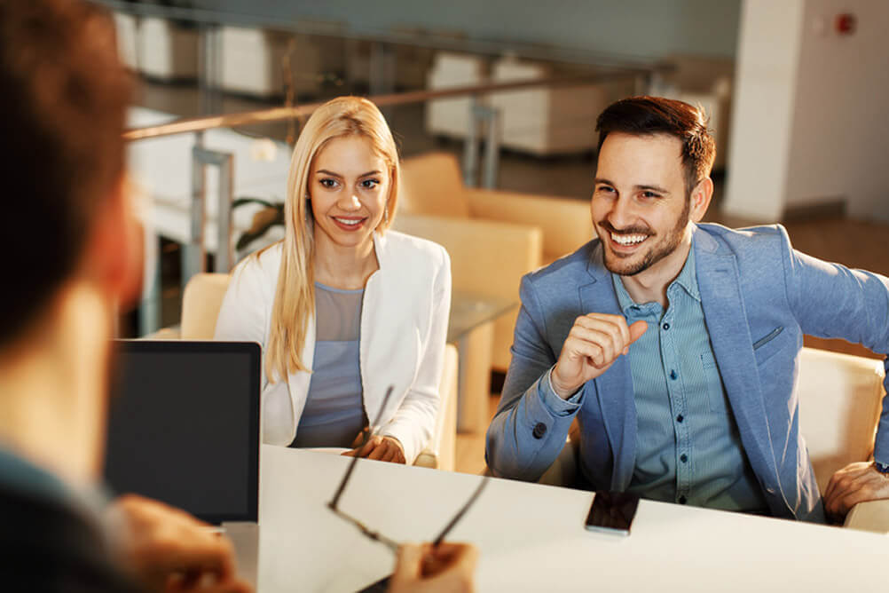 Ten tips for lottery winners Couple sitting at a desk with a financial advisor.