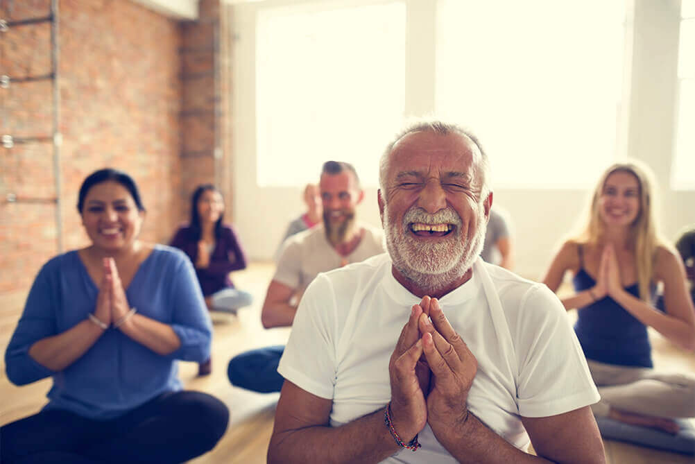 Group of smiling people doing yoga