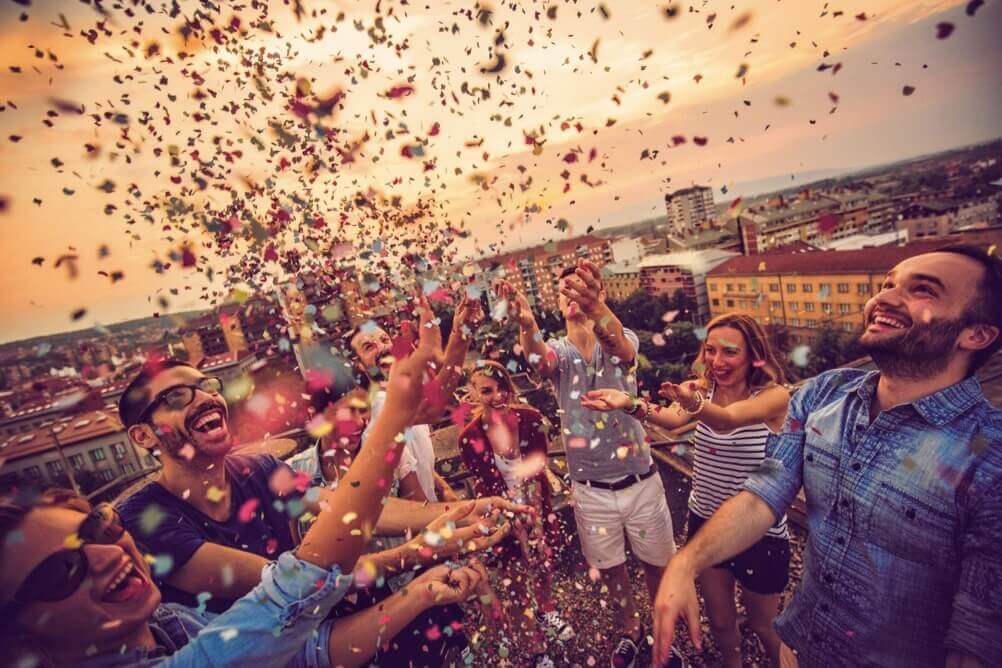 People celebrating a famous lottery win by throwing confetti in the air