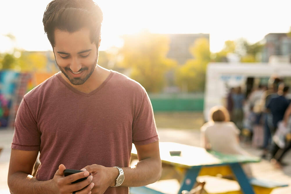 Man looks at his phone to check results of Kerala lottery