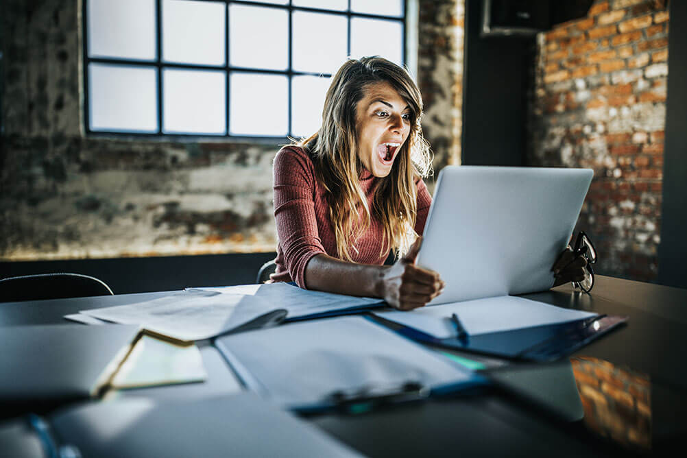 Woman screams with delight while reading online article about crazy lottery facts