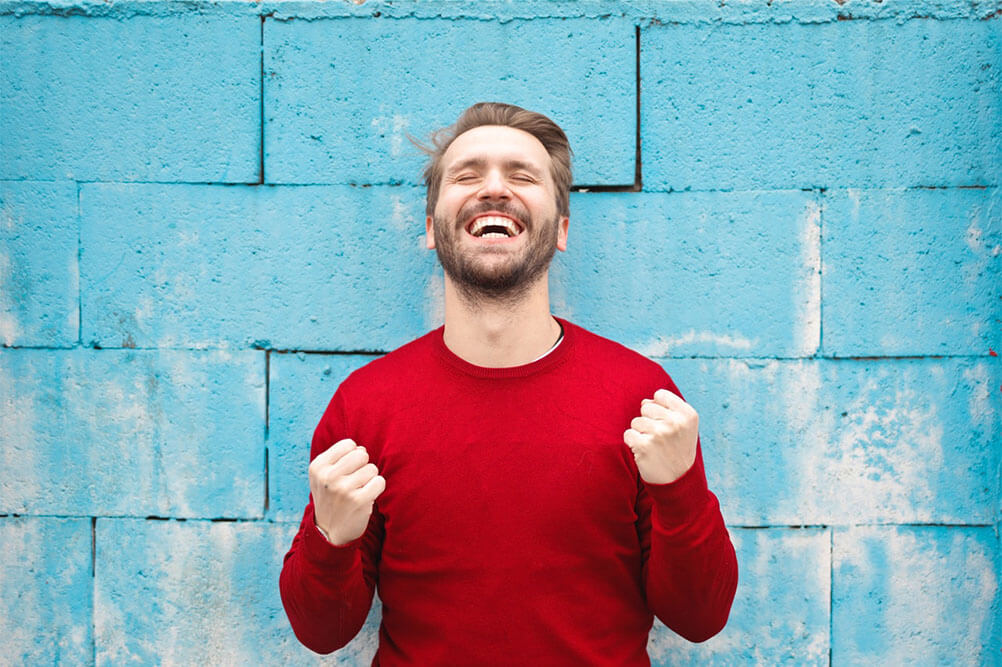 Man in red top celebrating lottery win