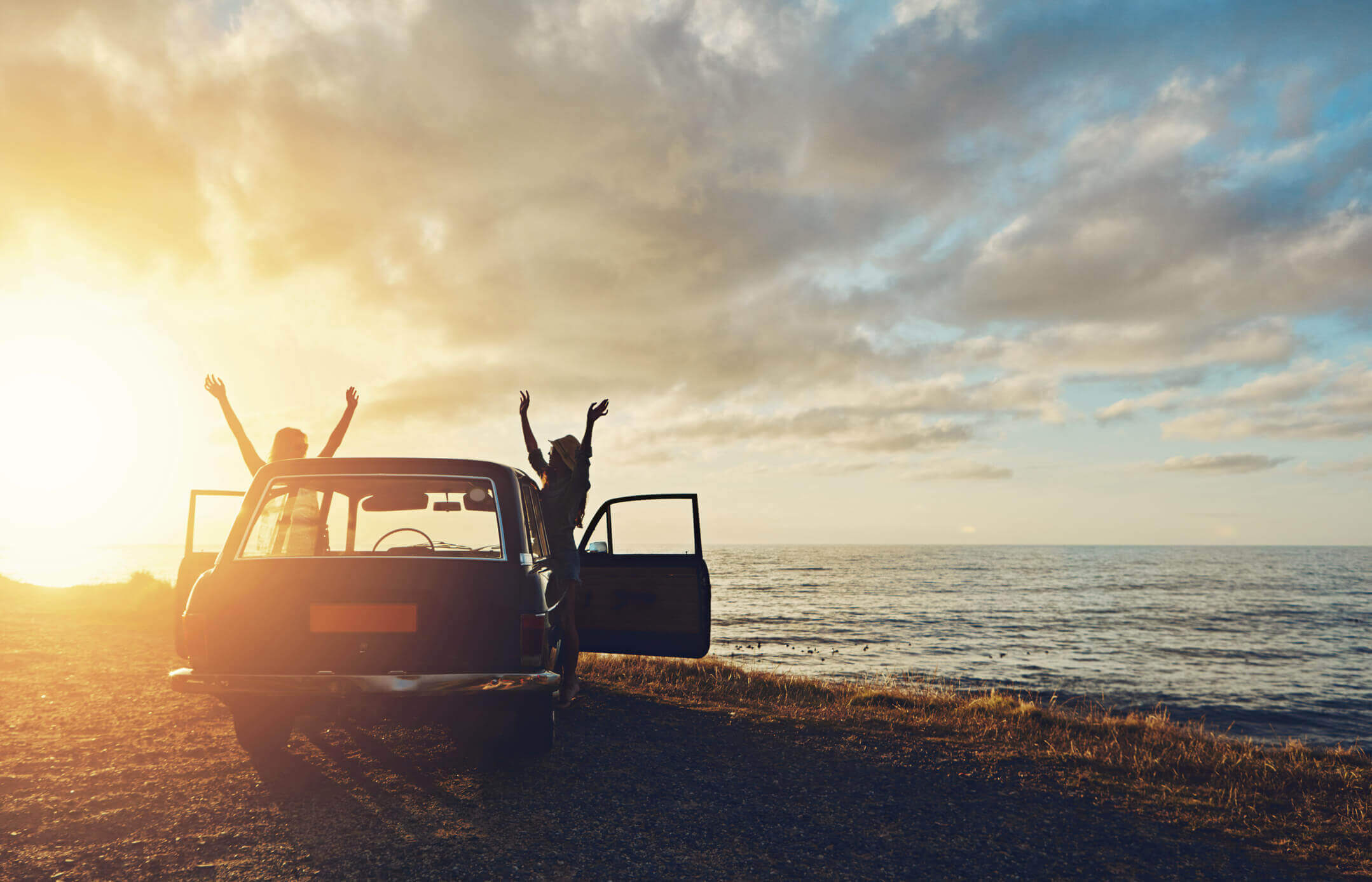 Couple leave their car and greet the dawn to celebrate