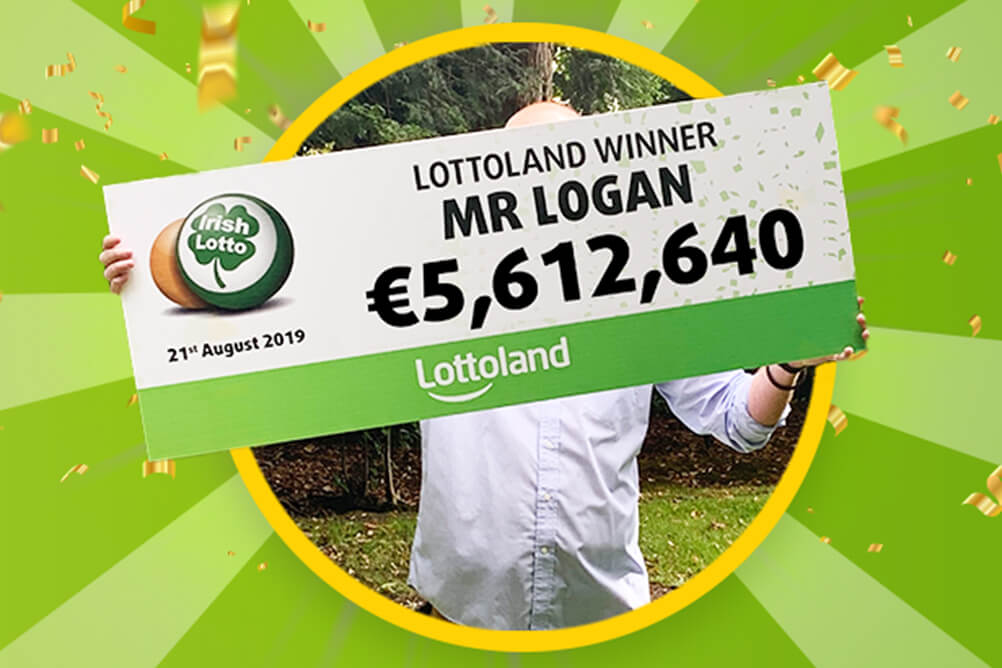 Mr Logan holds up cheque for €5.6 million after winning Lotto jackpot with Lottoland