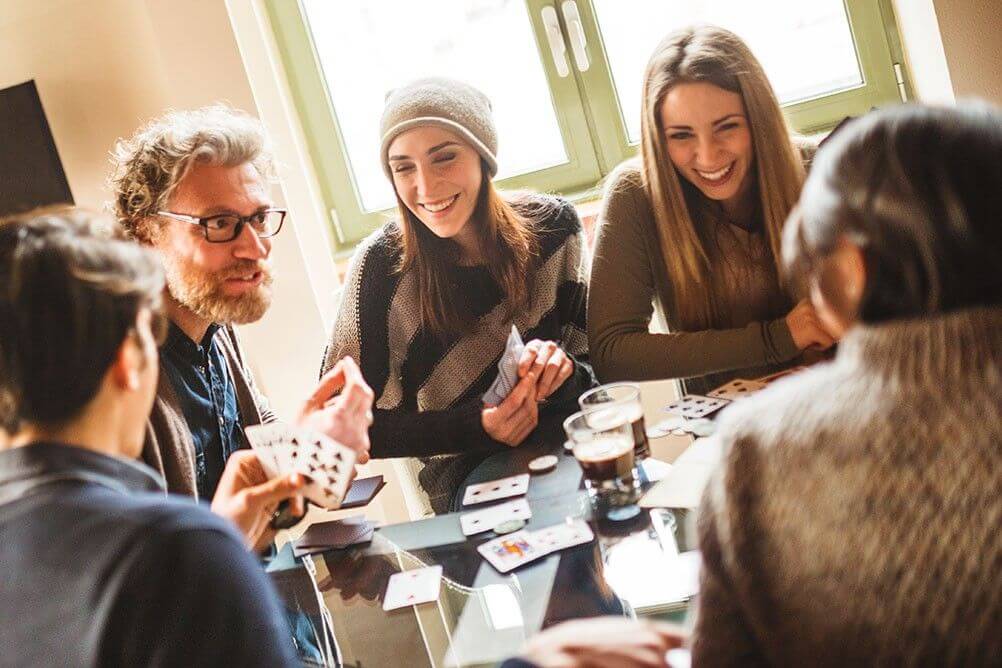 Group of friends playing poker hoping to be dealt a royal flush against the odds